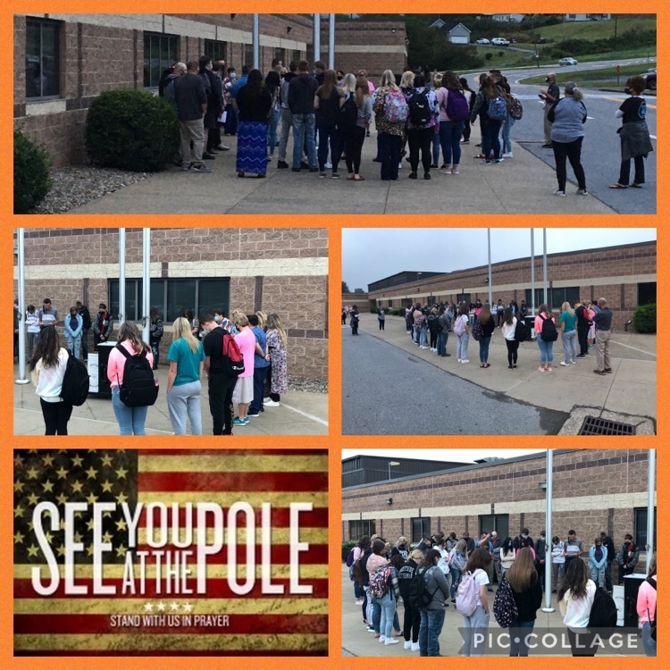 students saying prayer around a flag pole